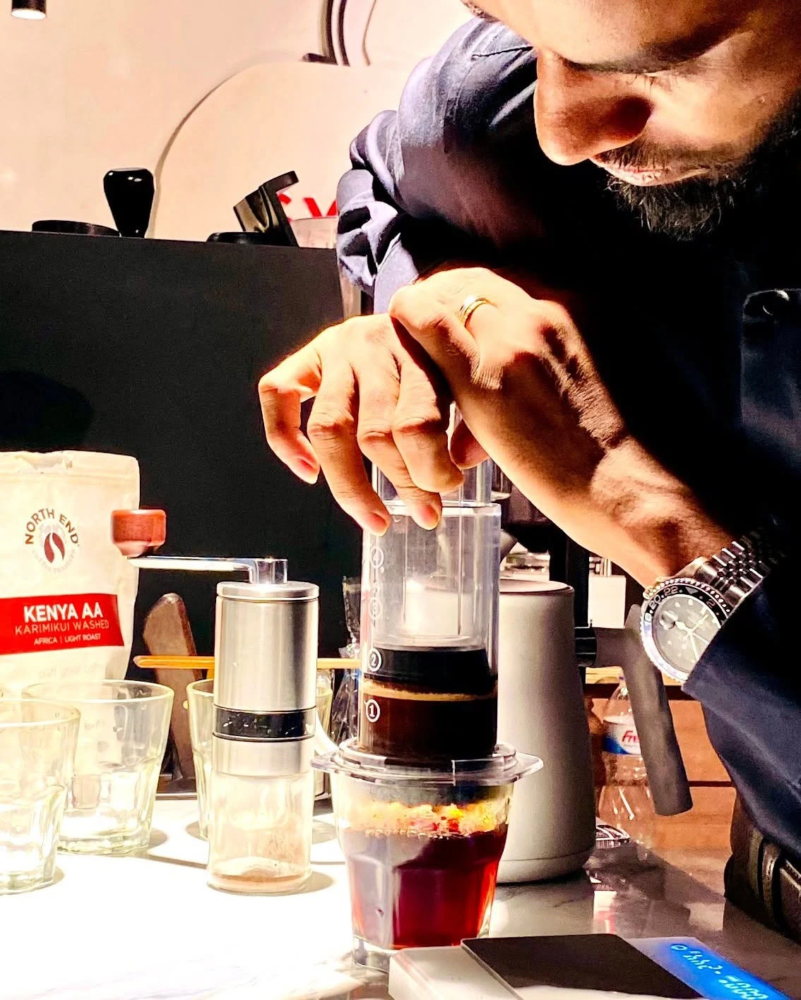 Barista Khan focusing on a manual brewing technique
