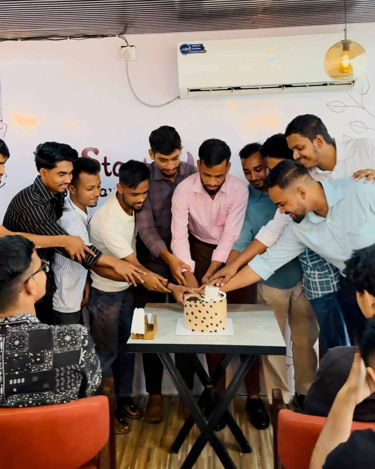 A group of learners practising coffee preparation with their instructor